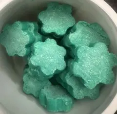 Türkisfarbene Urinalwürfel in Blumenform, 750 g, offen in einer weißen Schale präsentiert.