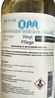 Vinylpflege500ml2 Transparente 500ml-Flasche Vinylpflege von OM mit orangefarbenem Etikett für Gastronomie und Hotelbedarf.